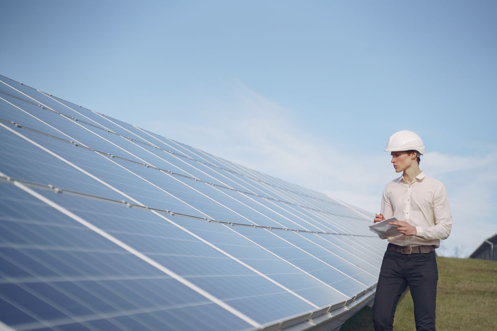 Integrador de energia solar analisando dados próximo a painéis solares